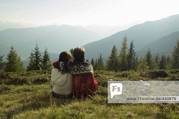 Young couple sitting in mountains