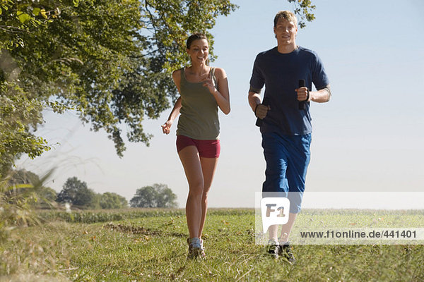 Young couple jogging in field
