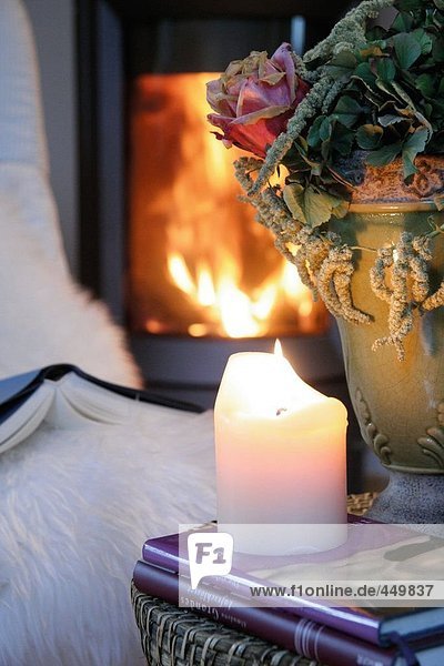 Close-up of lit candle on book