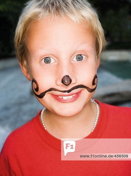 Ein Junge mit einem gemalten Schnurrbart.