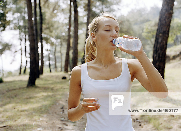 Eine Frau aus einer Flasche Wasser trinken.