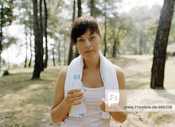 Eine Frau mit einer Flasche Wasser.