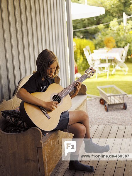 Teenager playing the guitar.