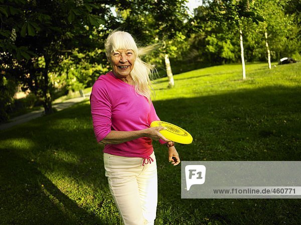 Eine Frau werfen ein Frisbee.