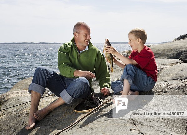 Father and son with caught fish.