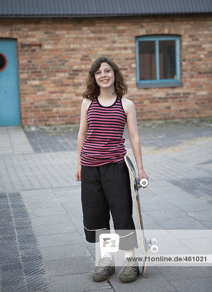 A teenage girl with a skateboard.