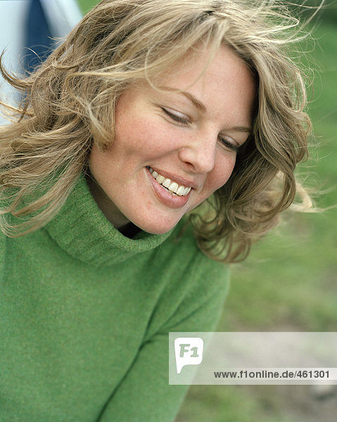 Laughing woman in a green sweater.