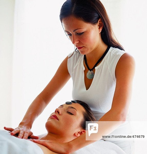 Close-up of young woman receiving front massage from therapist