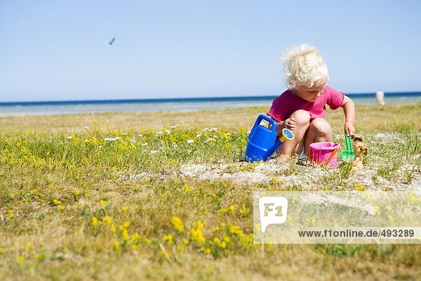 Ein kleines Mädchen am Strand spielen.