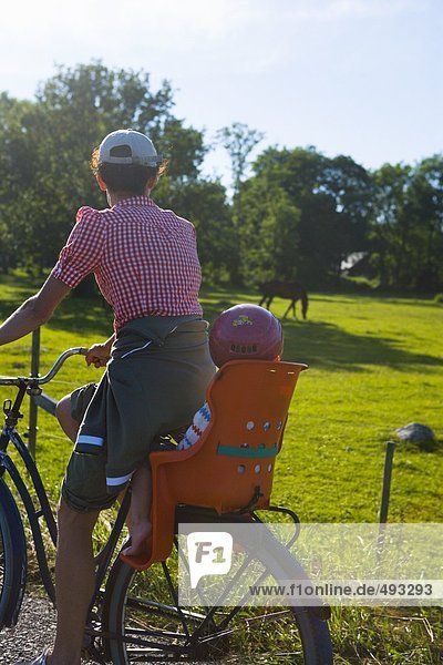 Mutter und Kind auf einem Fahrrad.