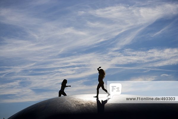 Silhouette von Kindern auf einem Trampolin.