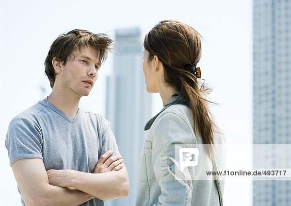 Young couple having argument in front of highrises