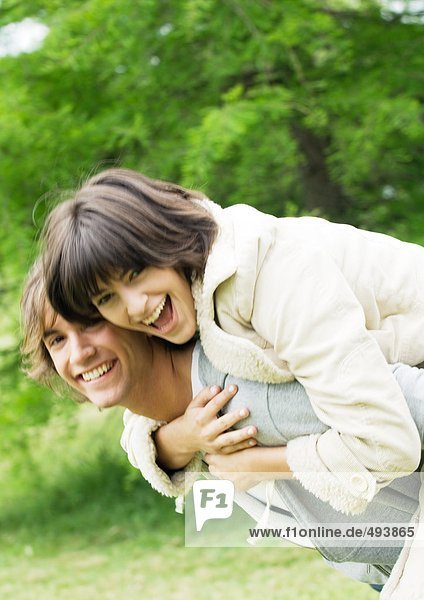 Young woman on man's back  smiling