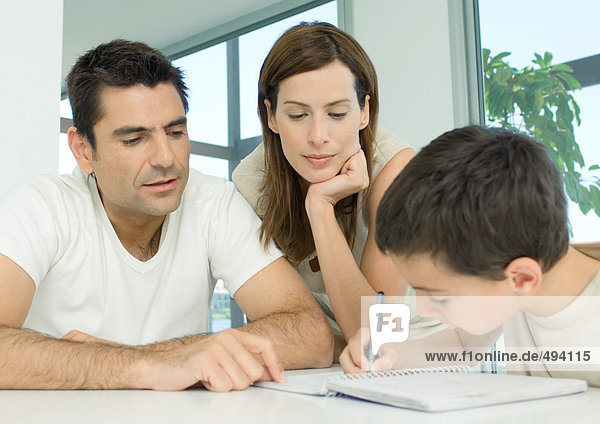 Eltern helfen dem Sohn bei den Hausaufgaben