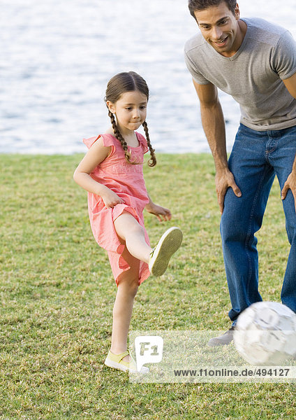 Mann spielt Fußball mit Tochter