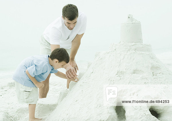Father and son building sand castle at the beach