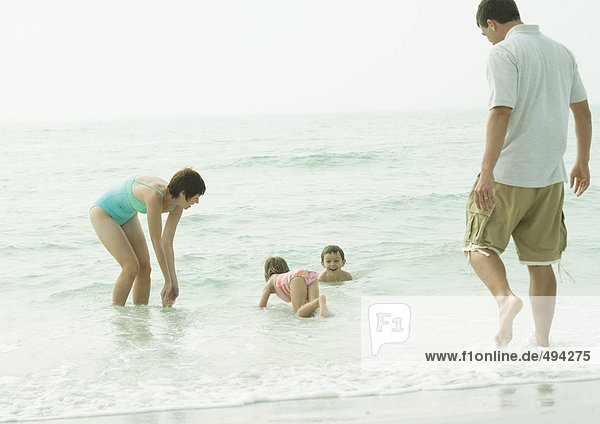 Familie am Strand  Spielen im Wasser