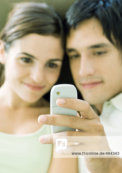Young couple looking at messaging phone