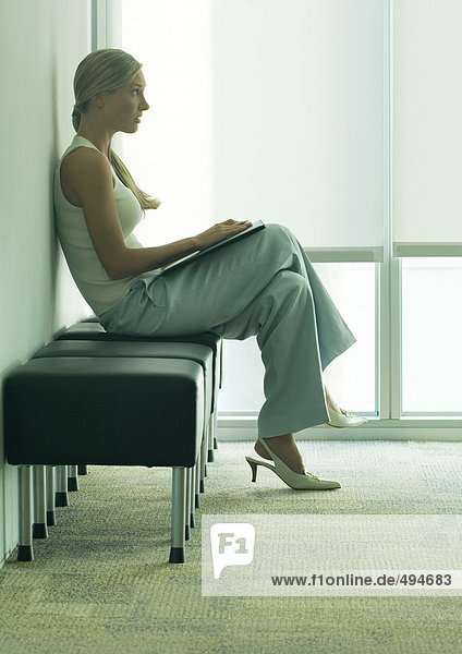 Frau sitzend im Wartezimmer