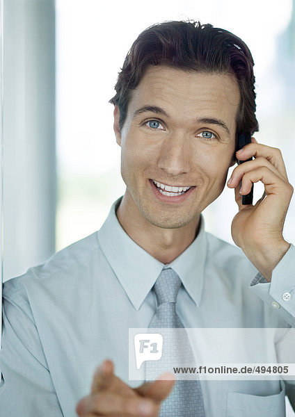 Businessman phoning and smiling