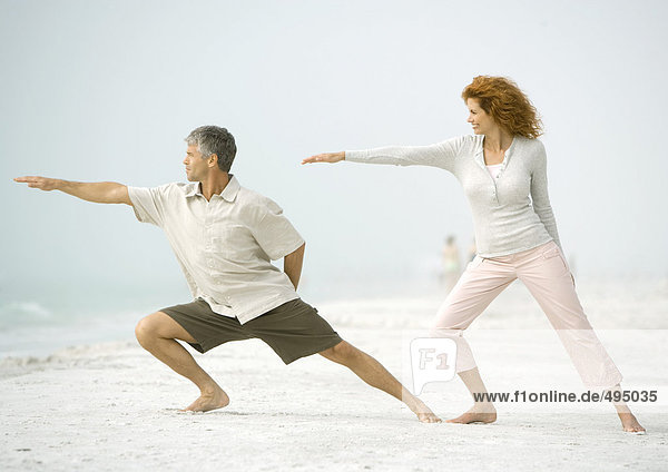 Couple doing relaxation exercises together on beach