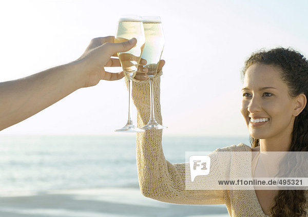 Couple clinking glasses of champagne  sea in background