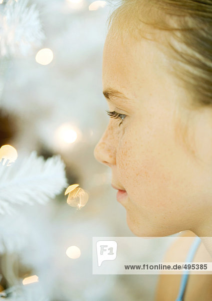 Girl looking at christmas tree  close-up