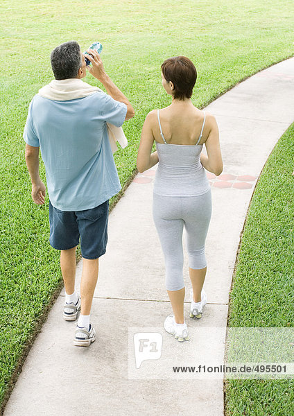 Mature couple walking on path after workout