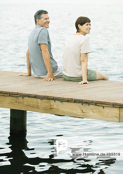 Couple sitting on edge of dock