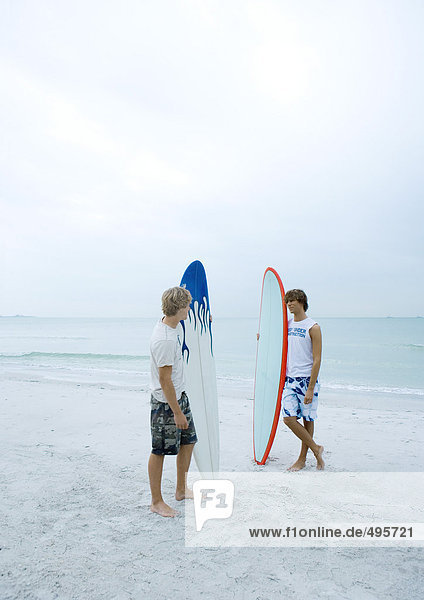 Zwei Surfer stehen am Strand