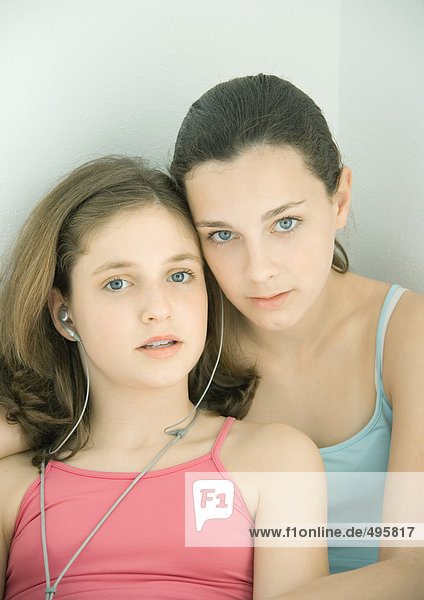 Zwei Mädchen  die sich Kopfhörer teilen