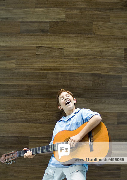 Junge spielt Gitarre und singt