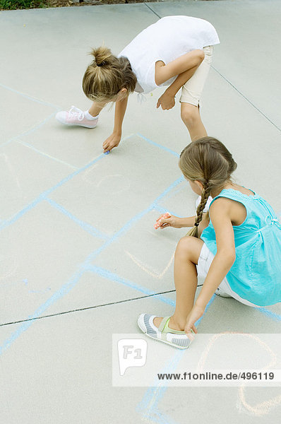 Mädchen malen Hopscotch-Spiel auf der Einfahrt