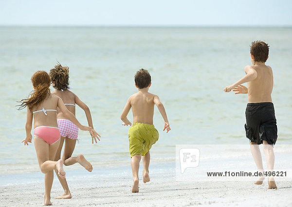 Children running together on beach