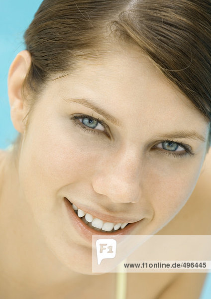 Young woman by pool  smiling  portrait