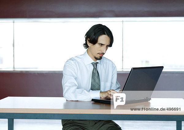 Geschäftsmann mit Laptop am Schreibtisch