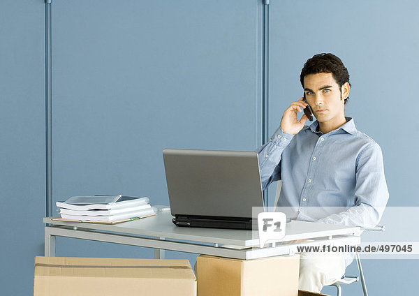 Mann am Schreibtisch sitzend  telefonierend