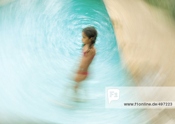 Girl standing in swimming pool  blurred motion