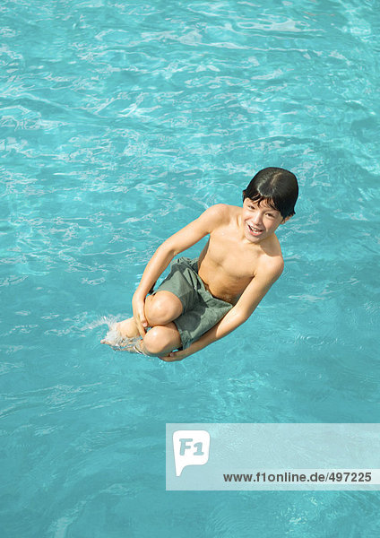 Junge springt in den Pool
