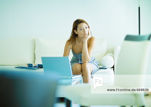 Woman sitting on sofa  using laptop