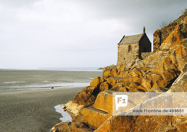 Steinhaus auf Felsen mit Blick auf den Strand