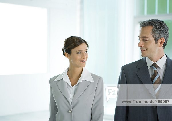 Businessman and businesswoman smiling at each other