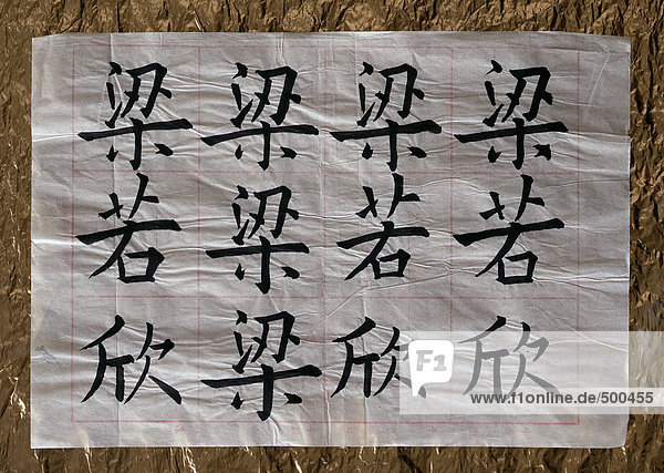 Chinesische Schriftzeichen auf zerknittertem Reispapier.