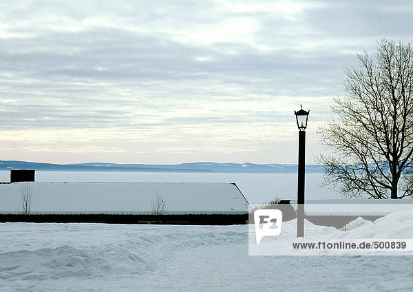 Finnland  schneebedeckte Häuser am Rande des Wassers