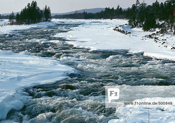 Schweden  Fluss  der durch verschneite Ufer fließt