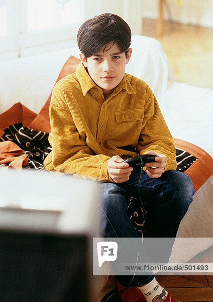 Junge spielt Videospiele auf der Couch.