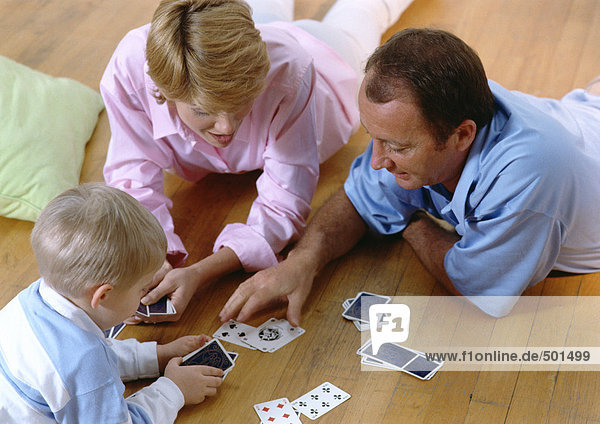 Parents playing cards with child  on floor  high angle view