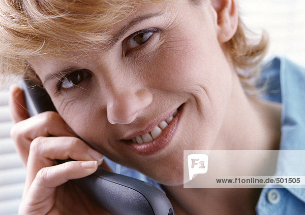 Woman on telephone facing camera.