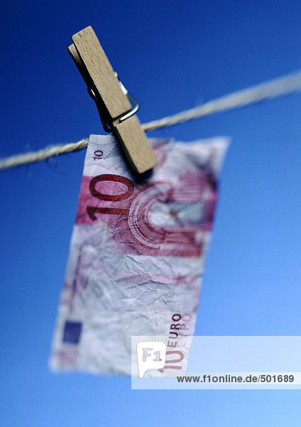 Zehn Euro-Schein an der Wäscheleine mit Wäscheklammer  Nahaufnahme.