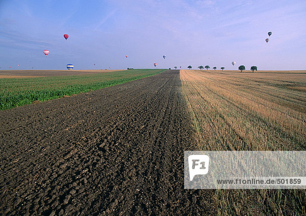 Frankreich  Lothringen  gepflügtes Feld mit Heißluftballons in der Ferne
